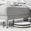 Höhenverstellbarer Möbelfuß in moderner Edelstahl-Optik unter einem grauen Sofa – ideal für mehr Bodenfreiheit und kompatibel mit Saugrobotern.