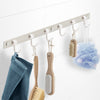 Garderobenleiste Modell Chiara mit sechs Wandhaken und Badezimmer-Zubehör daran hängend