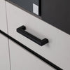 Schwarzer Möbelgriff an einer Schublade eines weißen Schranks montiert