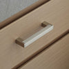 Schubladengriff quadratisch an einer Holz Schublade befestigt.